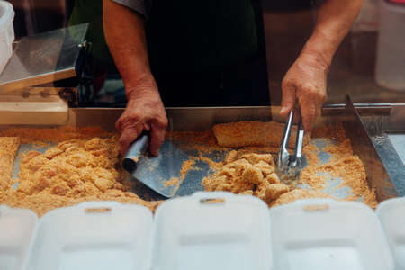 Kuala Lumpur, Malaysia - March 17, 2016: Famous madam Tang cooks Muah Chee desert at Petaling street, Chinatown on March 17, 2016 in Kuala Lumpur, Malaysiaのeditorial素材