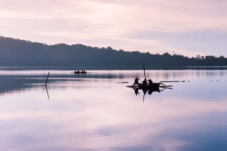 Fishermen boats on the Bratan Lake during sunrise, Bedugul, Bali, Indonesiaの写真素材