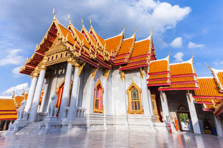 Bangkok, Thailand - September 10, 2016: Buddhist monk stands on the stairs of Wat Benchamabophit also known as Marble Temple at sunset on Septemper 10, 2016 in Bangkok, Thailand.のeditorial素材