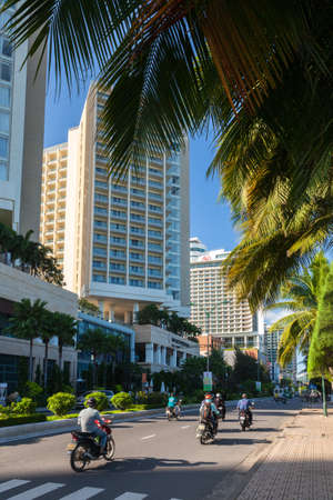 Nha Trang, Vietnam - December 09, 2015: Local people riding a motorbike in front of the luxury hotels on the seafront area on December 09, 2015 in Nha Trang, Vietnam.のeditorial素材