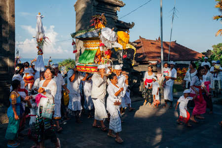 Bali, Indonesia - March 07, 2016: Balinese people in traditional clothes carry jempana or wooden litter at the procession during Balinese New Year celebrations.のeditorial素材