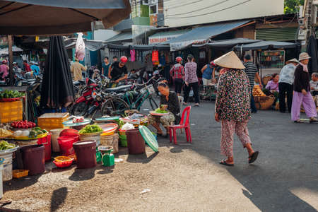 Nha Trang, Vietnam - July 14, 2016: Vietnamese woman in conical hat walks at the morning market in Nha Trang, Vietnam on July 14, 2016.のeditorial素材