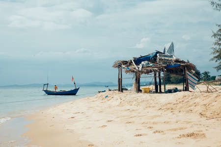 Phu Quoc, Vietnam - April 6, 2014: A local boy working on a fishing boat at the beach in Phu Quoc island, Vietnam on April 6, 2014.のeditorial素材