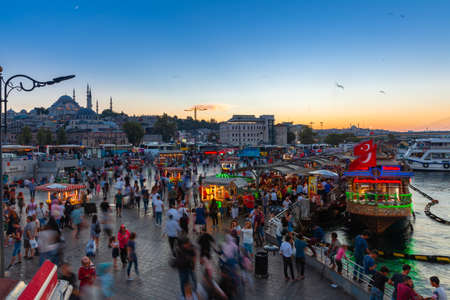 Istanbul, Turkey - August 14, 2018: People eat and walk at the Eminonu Square at dusk on August 14, 2018 in Istanbul, Turkeyのeditorial素材
