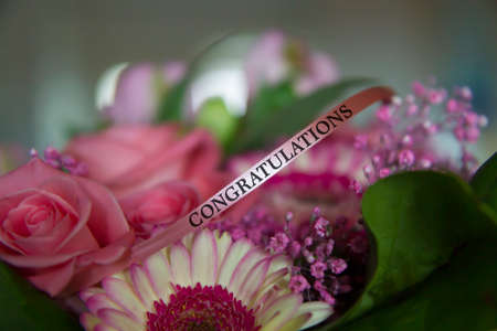 Flower bouquet with a ribbon saying Congratulationsの写真素材