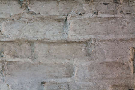 Old brick wall with dirty white plaster.の写真素材