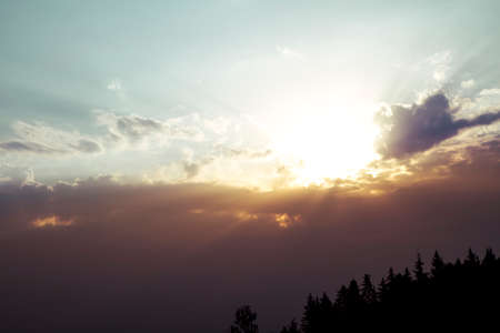Sun emerges behind the storm clouds casting god rays. Concept: God, hope, redemption, heaven and new beginningsの写真素材