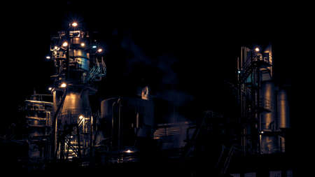 Industrial chemistry plant at night with golden and blue lights.