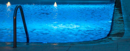 Empty swimming pool at dark with blue lightsの写真素材