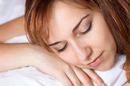 Closeup portrait of a beautiful young lady sleeps on the bed.