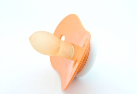 Orange pacifier on white background. の写真素材