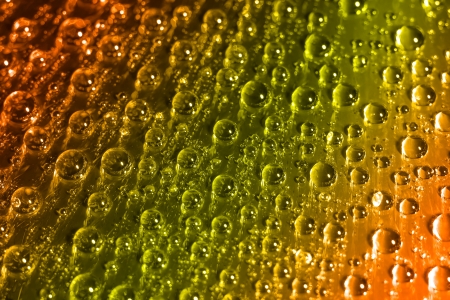 Water drops on dvd-disk, yellow-orange gradient  の写真素材