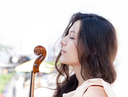 Girl and violin. Outdoors.の写真素材