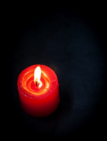Candle with flame on black background.の写真素材