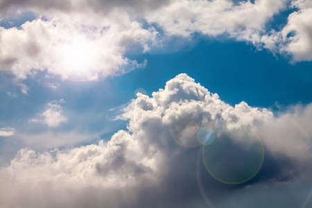 Cloudy sky with sun and glare.の写真素材