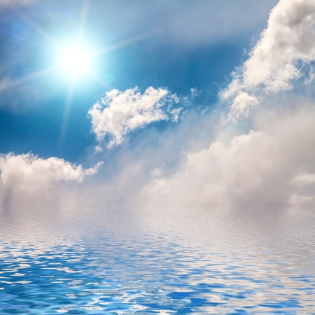   Sky with clouds and sun reflected in water surface の写真素材