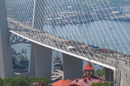 VLADIVOSTOK, RUSSIA - JULY 7: Flashmob "I love Vladivostok" on the "Golden Bridge". It was attended by 26,904 people who   have created a "live" 707-meter Russian flag for 5 minutes for Guinness world record on July 7, 2013 in Vladivostok, Russia. のeditorial素材