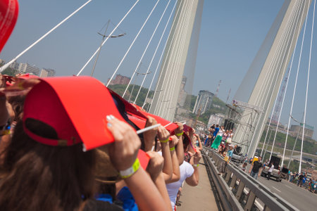 VLADIVOSTOK, RUSSIA - JULY 7: Flashmob "I love Vladivostok" on the "Golden Bridge". It was attended by 26,904 people who   have created a "live" 707-meter Russian flag for 5 minutes for Guinness world record on July 7, 2013 in Vladivostok, Russia. のeditorial素材