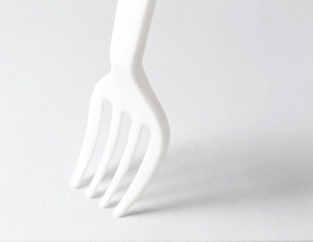    Plastic fork on white background with shadowの写真素材