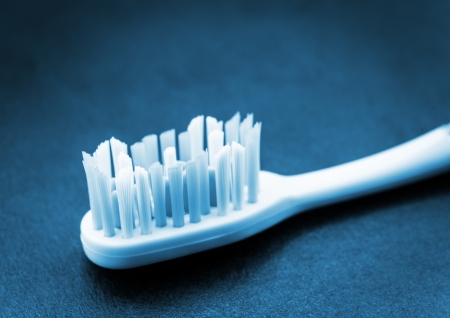 Toothbrush on dark surface  Blue toned image の写真素材