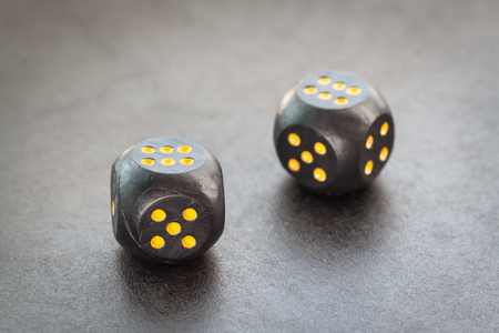   Two black dice on dark Selective focus with shallow depth of field  