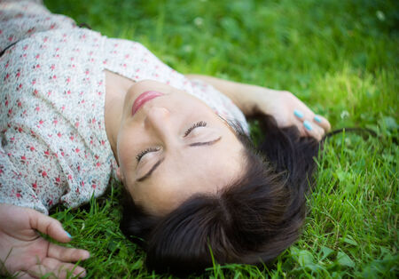  Cute young woman lying on the grass  Soft focus with shallow depth of field  