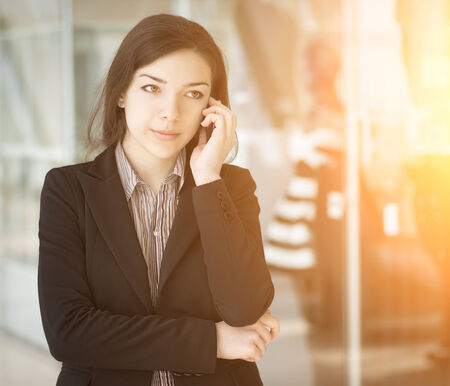    Young girl speaking by phone in the sunshine  Selective focus  の写真素材