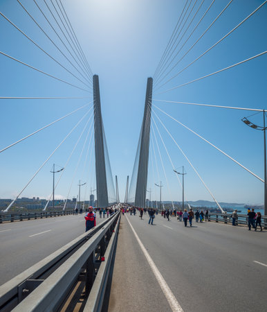 VLADIVOSTOK, RUSSIA - MAY 1, 2014  Citizens walk on  Golden Bridge  in International Workers  Day...