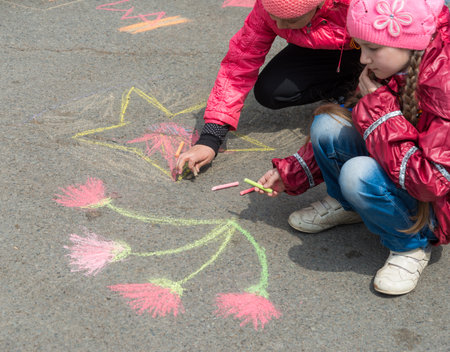  VLADIVOSTOK, RUSSIA - MAY 9, 2014  Children drawing on the asphalt flowers during festivities devoted to Victory Day のeditorial素材