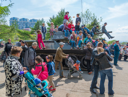   VLADIVOSTOK, RUSSIA - MAY 9, 2014  Children play on restored T-34 medium tank during festivities devoted to Victory Day のeditorial素材