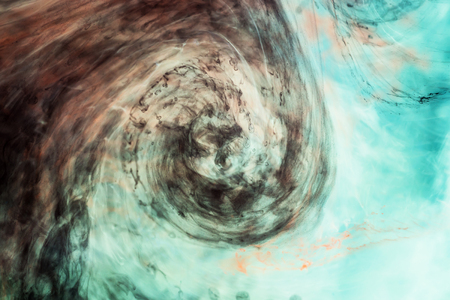  Dark watercolor in water with small pieces of paint の写真素材