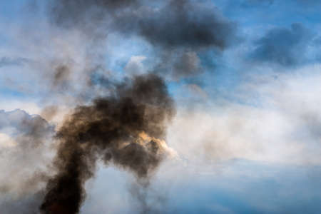   Black smoke over cloudy sky の写真素材