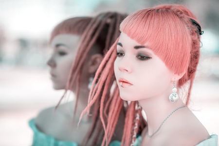 Portrait of a beautiful asian woman, outdoor. Reflection in the mirror. Color toned image.の写真素材