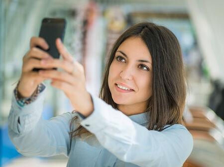 Young woman making selfie photo with her smartphone.の写真素材