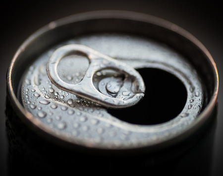 Opened aluminum can with water drops. Selective focus with shallow depth of field.