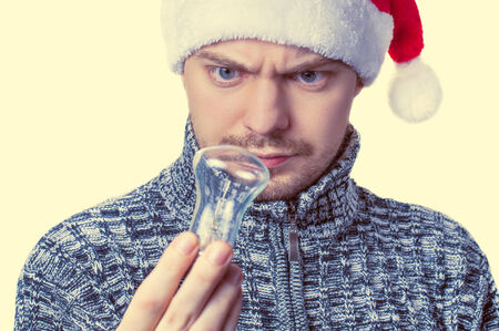 Man looking at light bulb in his hands. Conceptual of inspiration or imagination. Isolated. Color toned.の写真素材
