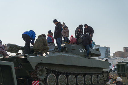 VLADIVOSTOK, RUSSIA - FEBRUARY 23, 2015: Children play on modern russian armored vehicle during...