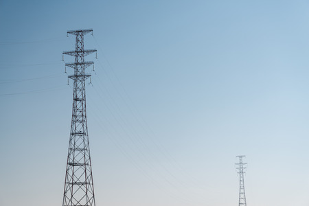 Two high-voltage towers against blue sky.