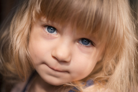 Close-up portrait of adorable smiling little girl. Selective focus with shallow depth of field.の写真素材