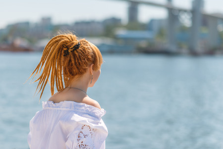 Young asian woman looking on sea. Photo from behind.の写真素材