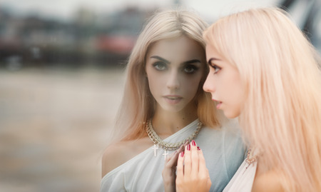 Portrait of a beautiful blonde girl. Reflection in the mirror.の写真素材