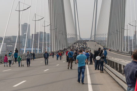 VLADIVOSTOK, RUSSIA - MAY 1, 2015: Citizens walk on \"Golden Bridge\" in International Workers\' Day event. International Workers\' Day is a celebration of labour and the working classes.のeditorial素材