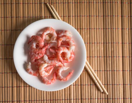 Cooked shrimps and chopsticks. Selective focus and shallow depth of field.の写真素材