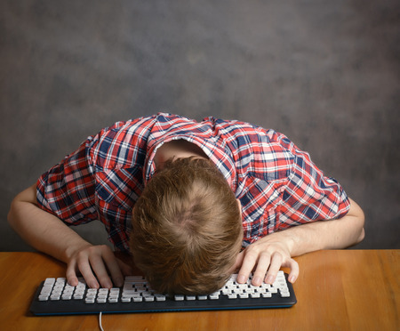 Man sleeping on his keyboard.の写真素材