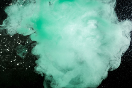 Drops of blue ink flowing through water.の写真素材