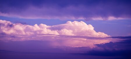 Dramatic sunset sky with pink colored clouds. Toned image.の写真素材