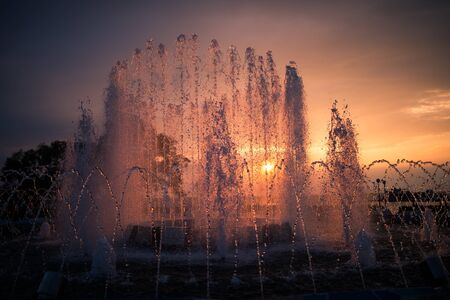City fountain at sunset. Selective focus with shallow depth of field.の写真素材