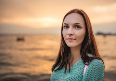Portrait of a beautiful young woman at sunset.の写真素材