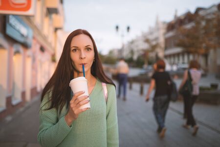 Funny young woman in urban place with coffee.の写真素材
