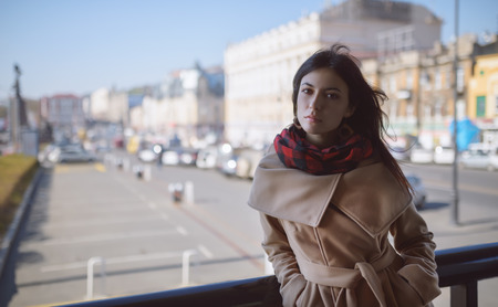 Young woman in a coat on the street.の写真素材